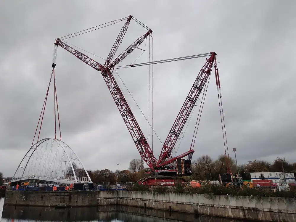 Crawler crane lifting a steel bridge section