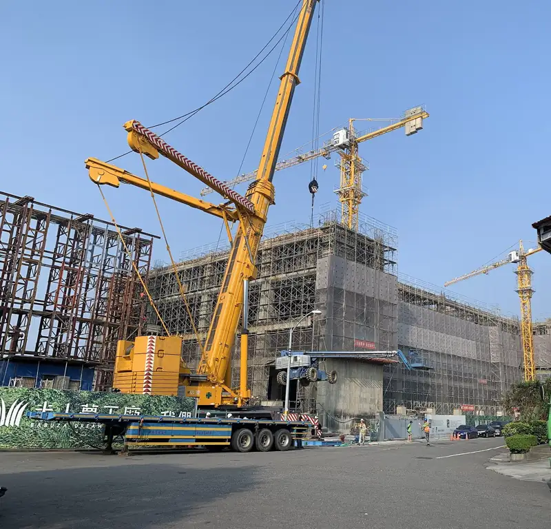 Eight-axle all-terrain mobile crane with its boom raised on a construction site